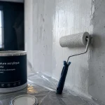 Peinture pour isolation thermique : rouleau sur mur et film isolant humide